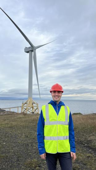 IDCORE Research Engineer - Jack Winfield standing in front of a wind turbine