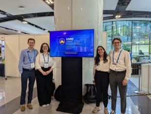 Jonathan and three colleagues at a display screen for OMAE 24 Conference