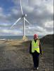 Maria standing in front of a wind turbine